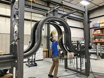Man standing under new dynamic walkway gripper conveyor